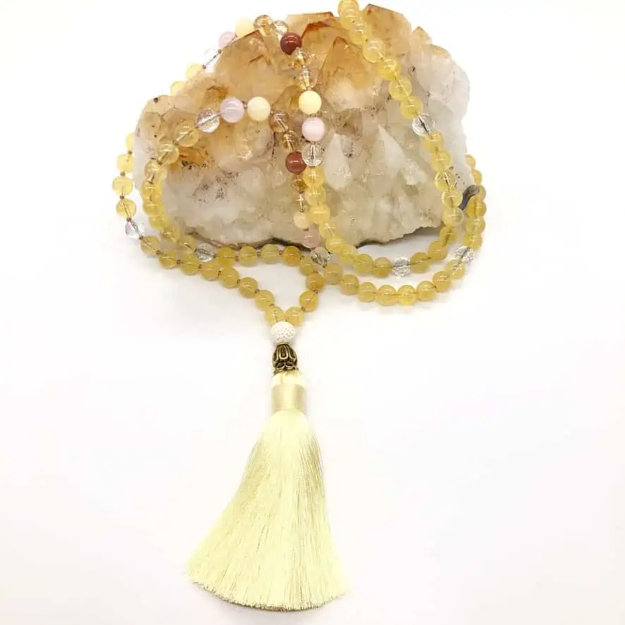 citrine mala necklace on top of citrine crystal