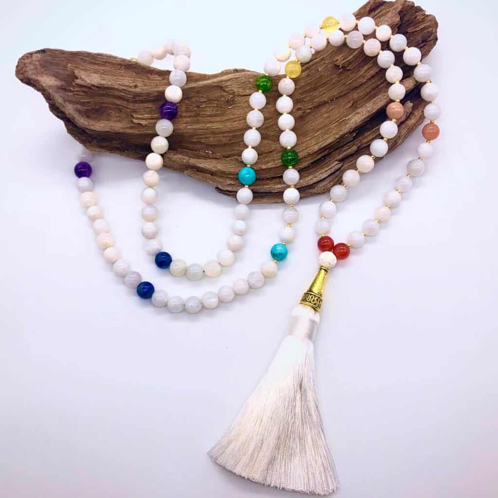 chakra mala necklace on top of wood